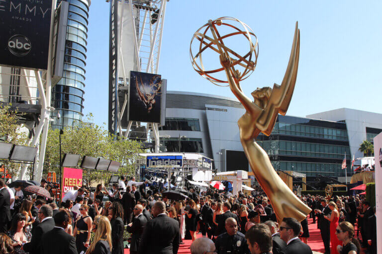 Giant Emmy Award statue over a captive audience outside.