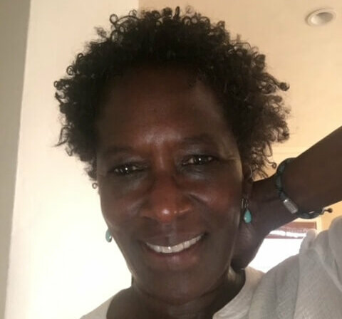 Casting Director Victoria Thomas smiling in her home wearing a white shirt.