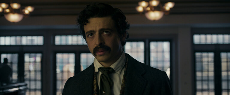 Anthony Boyle in 1800s clothes inside staring blankly.