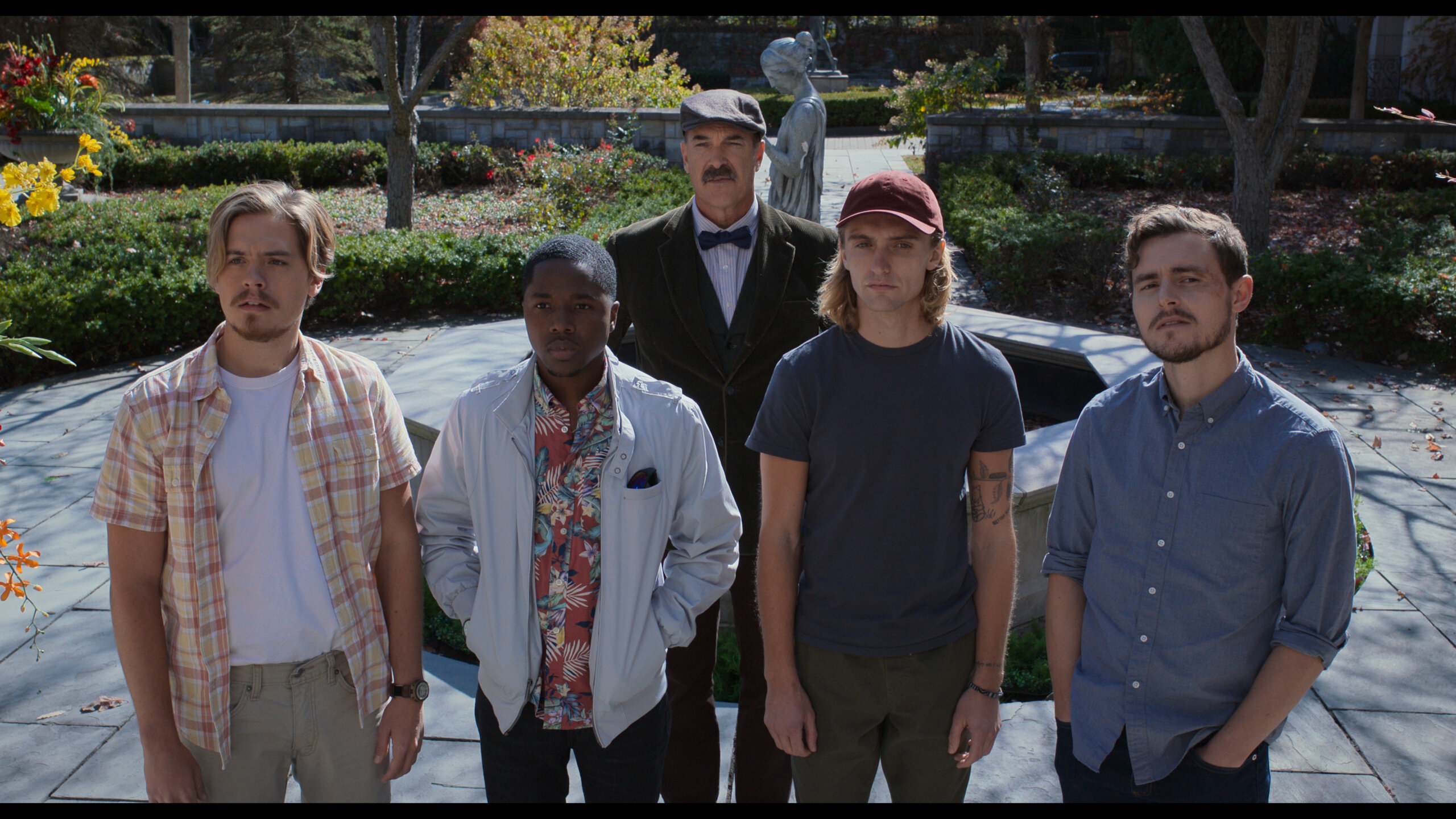 Patrick Warburton, Dylan Sprouse, Callan McAuliffe and others outside a mansion.