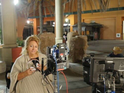 Michelle Danner sitting on a film set directing a movie outside.