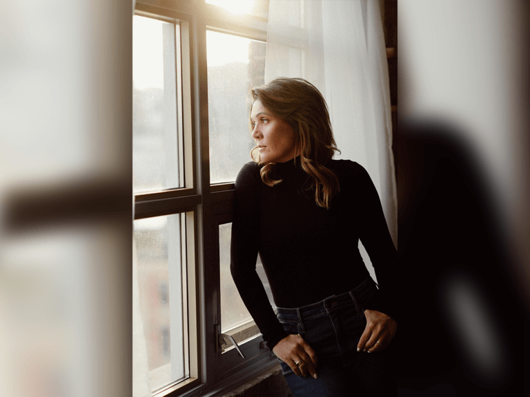 Casting Director Nicole Hilliard-Forde in a black sweater looking out a window.