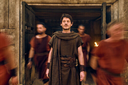 Iwan Rheonin walking in Roman peasant clothes in Peacock's 'For Those About to Die.'