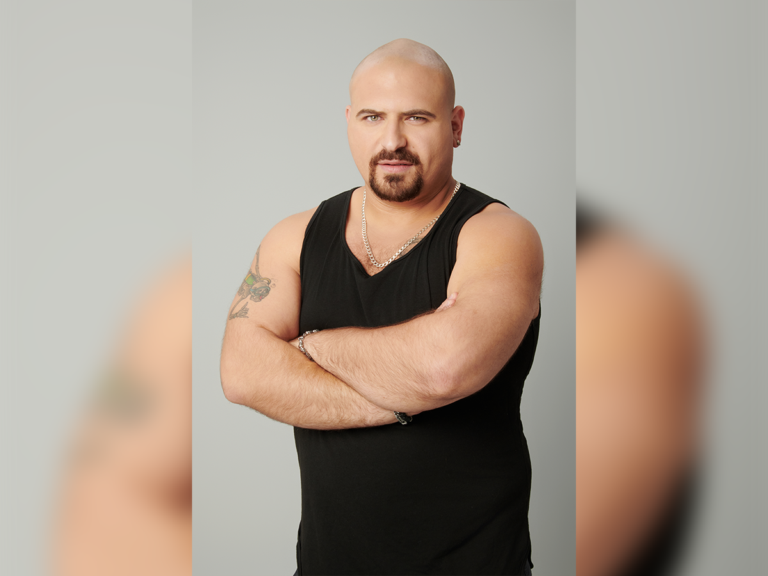 Actor Greg Hoffman in a black tank top looking tough.