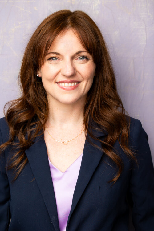 Christie Harms smiling in a trendy blue balzer.