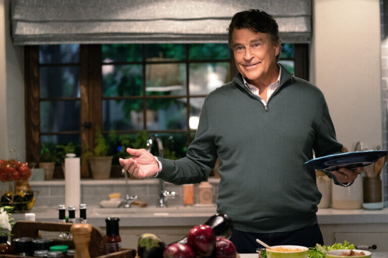 Ted McGinley in the kitchen making an expressive gesture in "Shrinking,"
