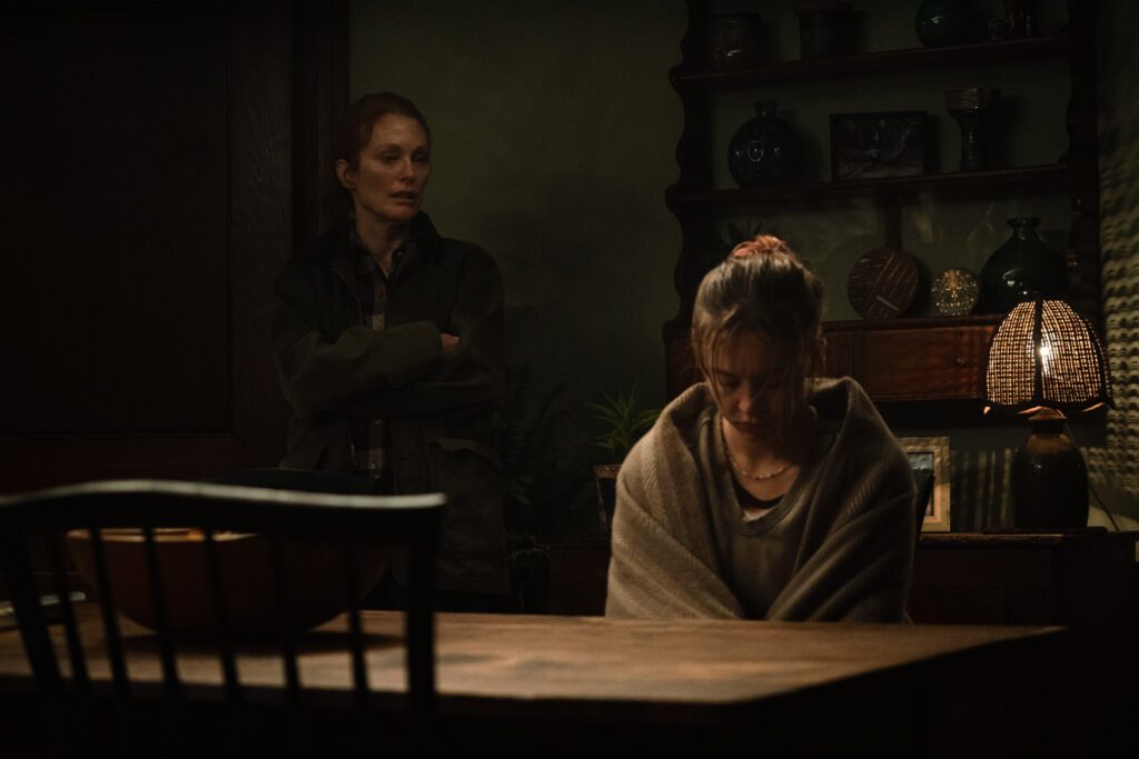Julianne Moore talking to Syndey Sweeney, who is upset and sitting at a table wrapped in a blanket.