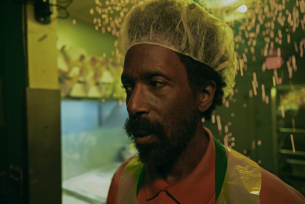 Ntare Guma Mbaho Mwine looking shocked and sadded while working at a donut shop.